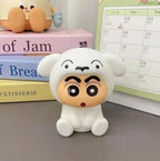 Cute cartoon figurine with a surprised expression on a surface with books and a calendar in the background.