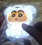Plush toy with cartoon face in clear packaging held by a hand