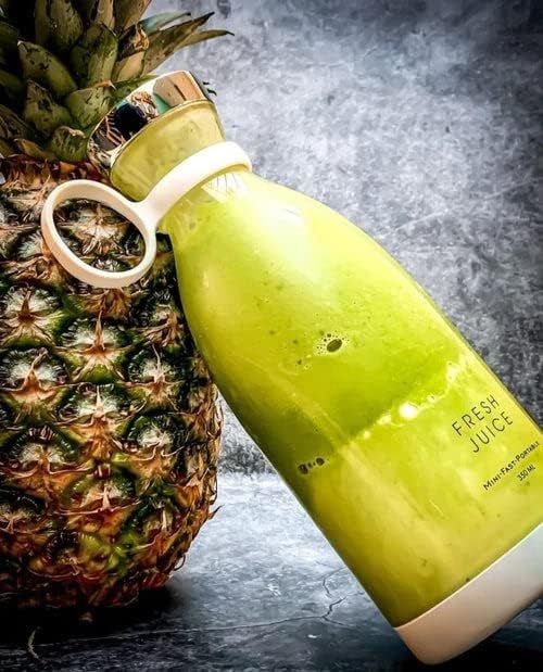 Green juice bottle with a pineapple on a dark surface